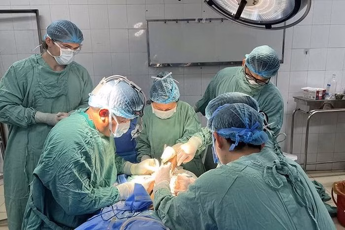 Các bác sĩ tập trung cao độ trong ca phẫu thuật tái lập tuần hoàn và nối chi thể cho bệnh nhân.